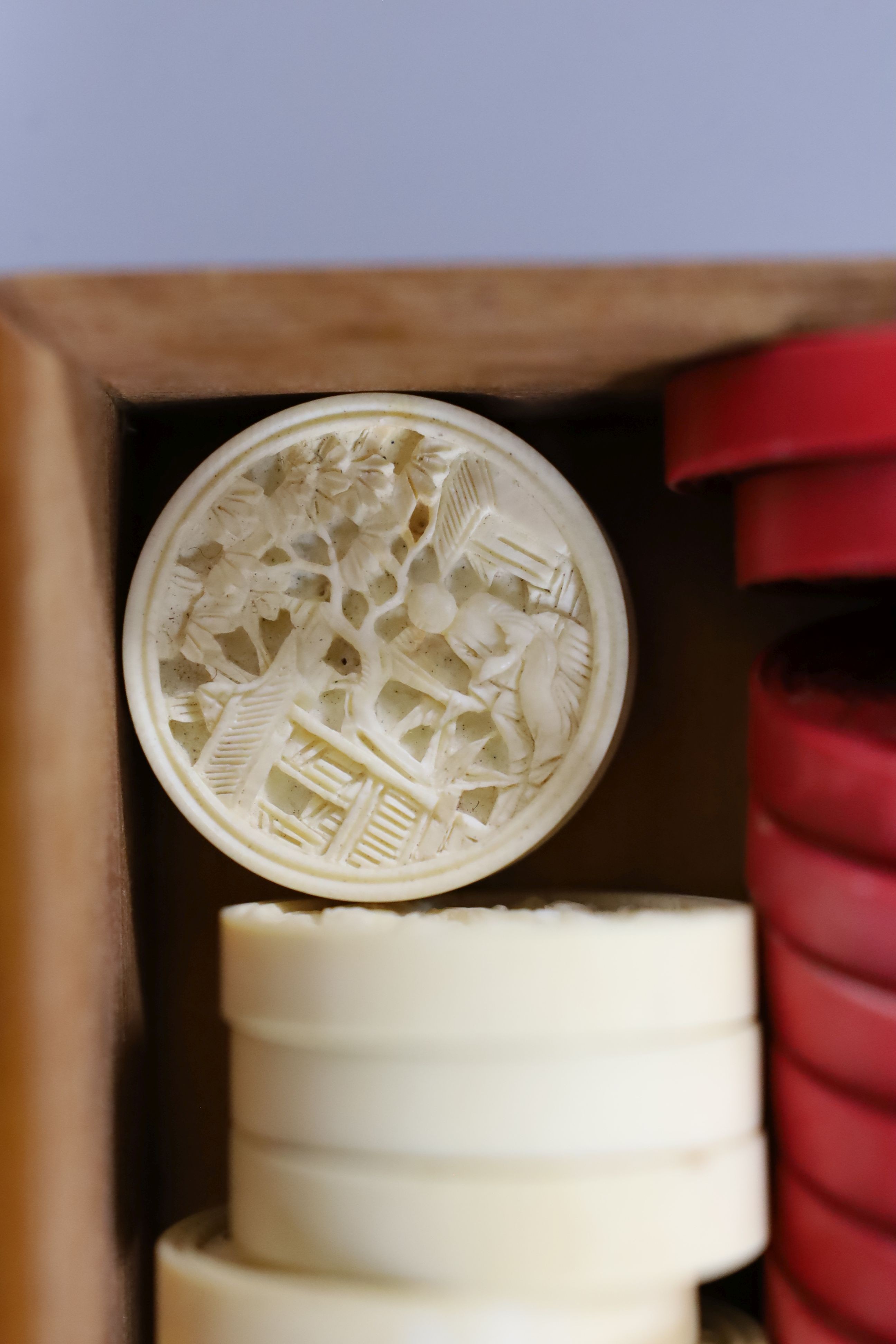 A 19th century bone and ivory draughts set, engraved mother of pearl gaming counters and stained bone tokens, all boxed